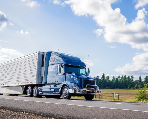 Side view of a semi-truck driving down the road