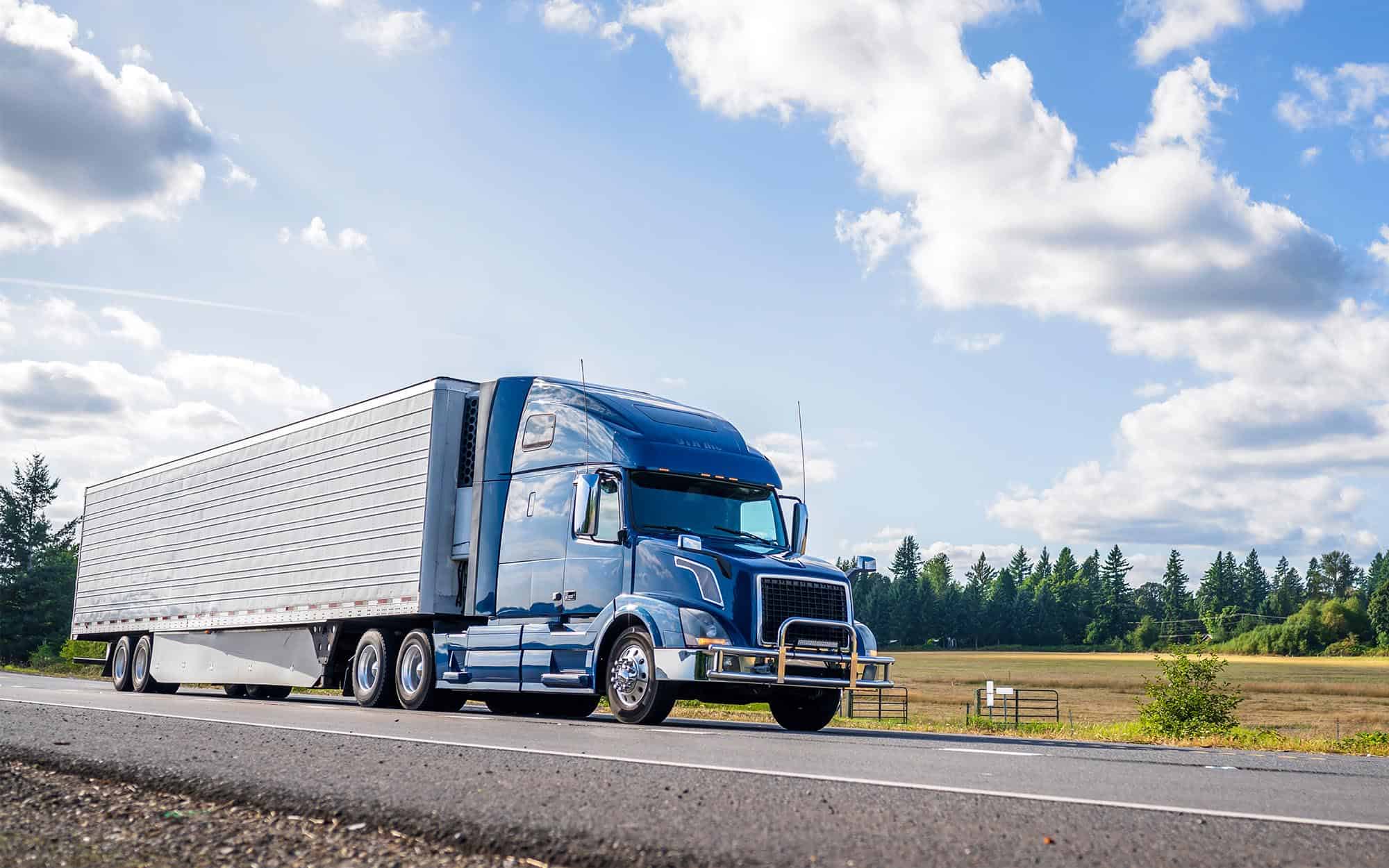 Side view of a semi-truck driving down the road