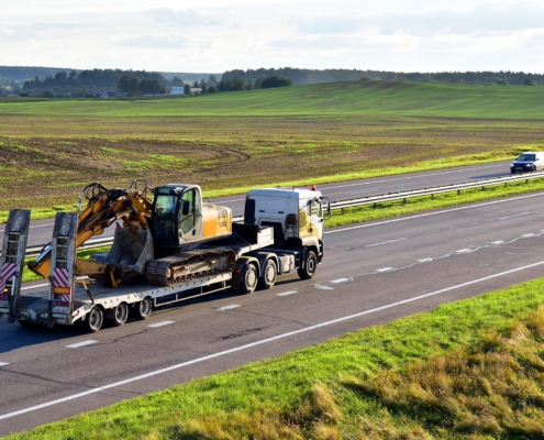 Trailer truck with long platform transport the Excavator on highway